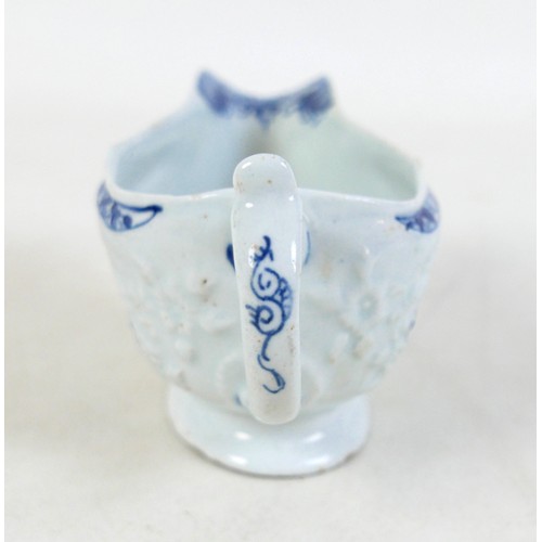 137 - An 18th century Lowestoft porcelain small sauce boat, decorated with moulded exterior and in undergl... 