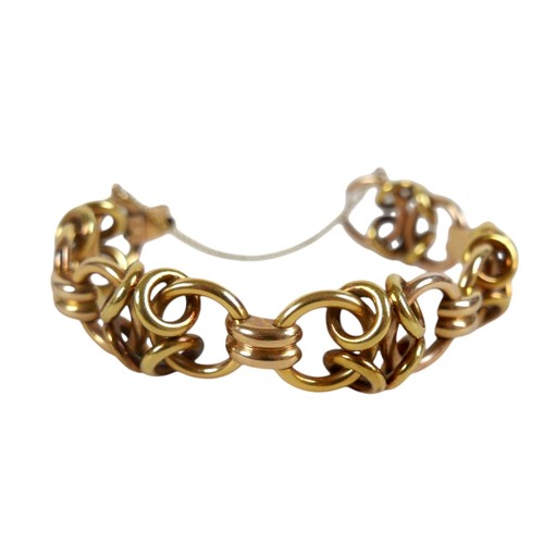 A vintage 18K yellow gold bracelet, circa 1950s, formed of various interlocking rings, with hinged clasp and attached safety chain, stamped 'NGF' and '18K', 22mm wide, 19cm long, 63.3g.