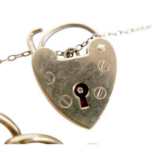 15 - A 9ct gold charm bracelet with heart lock, circular gold Taurus charm, wishbone charm, carriage with... 