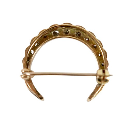 51 - A Victorian 9ct gold and diamond crescent shaped brooch, set with fifteen graduated diamonds, the la... 