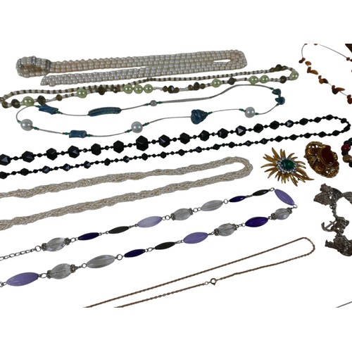 27 - A group of costume jewellery, including a square resin pendant, with abstract black, gold and amber ... 