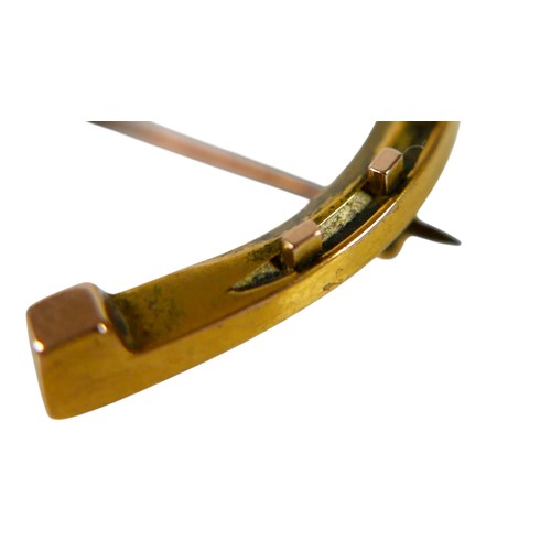 56 - A 15ct gold horseshoe brooch, with base metal pin, 3.8g overall. 3.2 by 3.5cm.