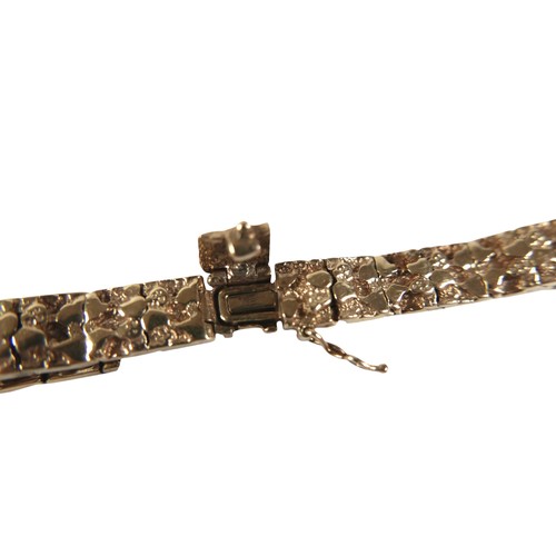 7 - A 14k yellow gold bracelet, with textured links, hinged box clasp with safety clip, 8.5mm wide, 18cm... 
