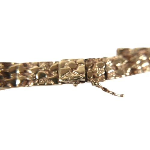 7 - A 14k yellow gold bracelet, with textured links, hinged box clasp with safety clip, 8.5mm wide, 18cm... 