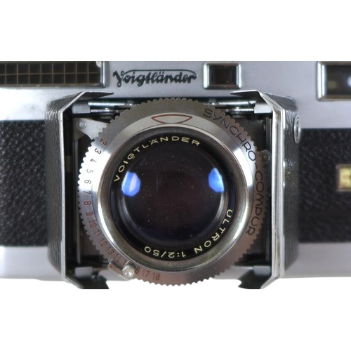 169 - A collection of nine vintage cameras comprising a Polaroid land camera, Voigtlander Vito B and Promi... 