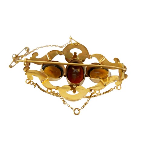 36 - A 19th century gold plated brooch with three oval citrine / brown stones, safety chain, 6cm by 3.5cm... 