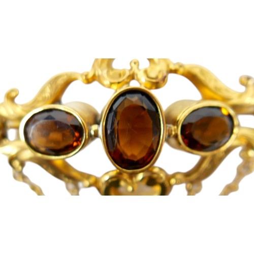 36 - A 19th century gold plated brooch with three oval citrine / brown stones, safety chain, 6cm by 3.5cm... 