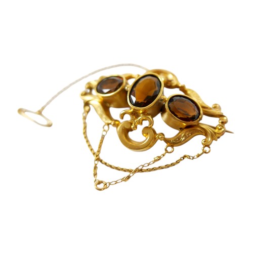 36 - A 19th century gold plated brooch with three oval citrine / brown stones, safety chain, 6cm by 3.5cm... 