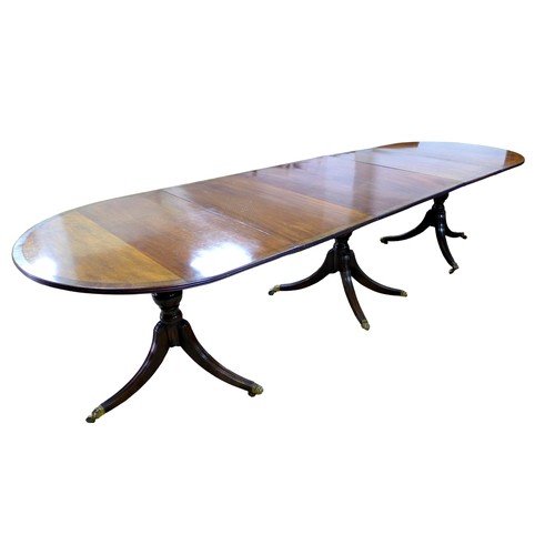 450 - A Regency style mahogany triple pedestal dining table, with cross banded decoration, raised on turne... 