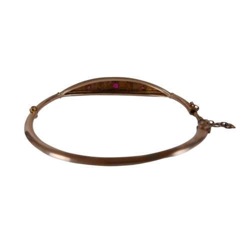 50 - A 9ct yellow gold diamond and ruby hollow bangle 6 x 6.5cm, weight 4.7g, with box.