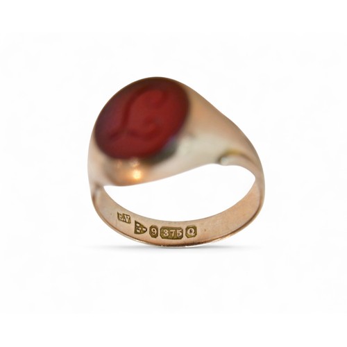 33 - A 9ct gold and a red stone inlaid signet ring, size P, 4.2g.