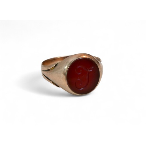 33 - A 9ct gold and a red stone inlaid signet ring, size P, 4.2g.