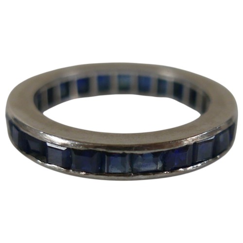 55 - A white metal sapphire eternity ring size O, 3.6mm band, weight 4.3g.