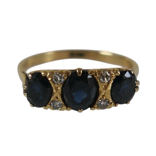 56 - An 18ct yellow gold sapphire and diamond ring set with three oval cut sapphires and four small diamo... 