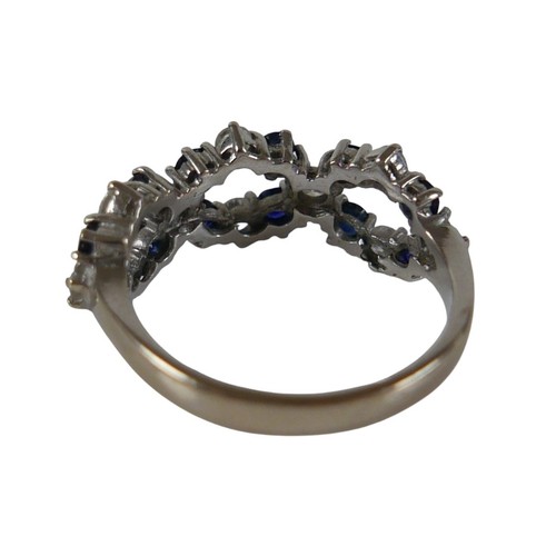 57 - An 18ct white gold diamond and sapphire ring set with twenty two interwoven stones, ring size O, wei... 