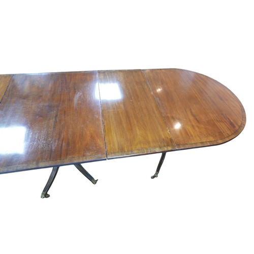 450 - A Regency style mahogany triple pedestal dining table, with cross banded decoration, raised on turne... 