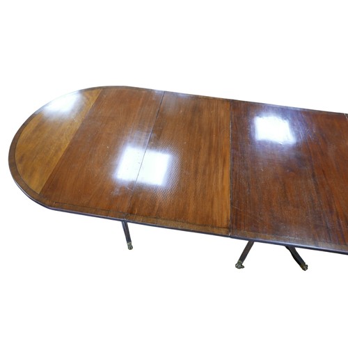 467 - A Regency style mahogany triple pedestal dining table, with cross banded decoration, raised on turne... 