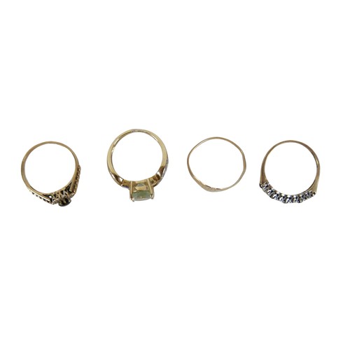46 - Four 9ct gold rings, including a large pale blue oval cut stone ring with two small diamonds to its ... 