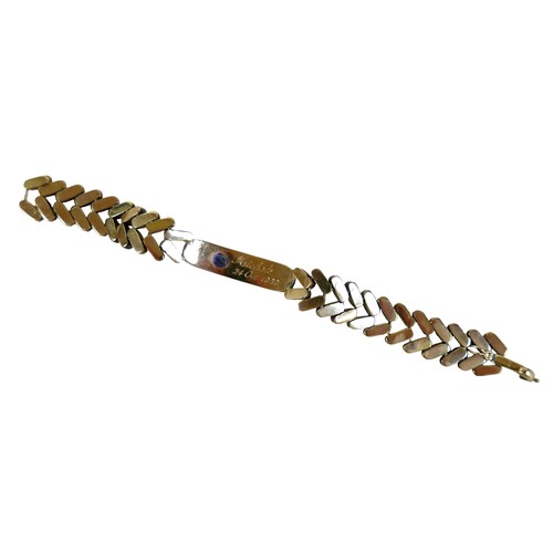 5 - A gold and sapphire identity bracelet, tested as 14ct appears to be stamped ‘14’, oval cut sapphire ... 