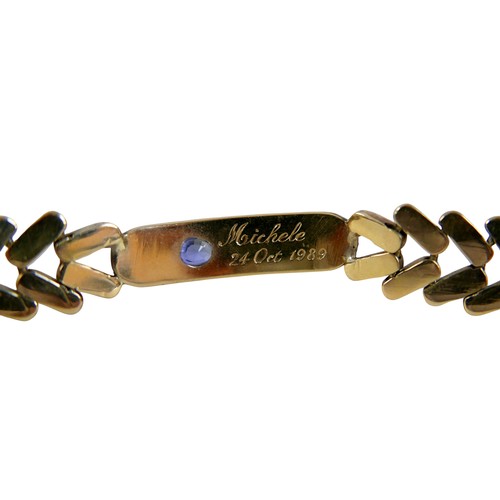 5 - A gold and sapphire identity bracelet, tested as 14ct appears to be stamped ‘14’, oval cut sapphire ... 