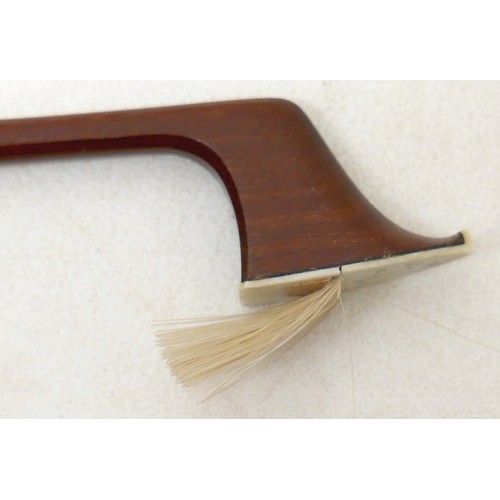27 - A violin bow, with ebonised and mother of pearl inlaid frog, 60g, 66cm long.