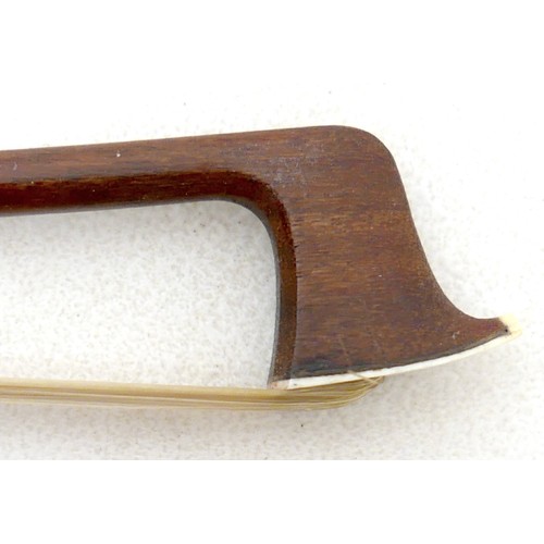 34 - A violin bow with engraved frog and ferrule, 60g, 73cm long.