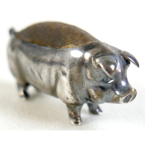 105 - An Edward VII silver pin cushion, in the form of a pig, Birmingham 1903, 5cm long, together with a s... 