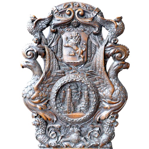397 - The Burghley Chair: a Victorian heavily carved oak Armorial hall chair, dated 1866, profusely carved... 