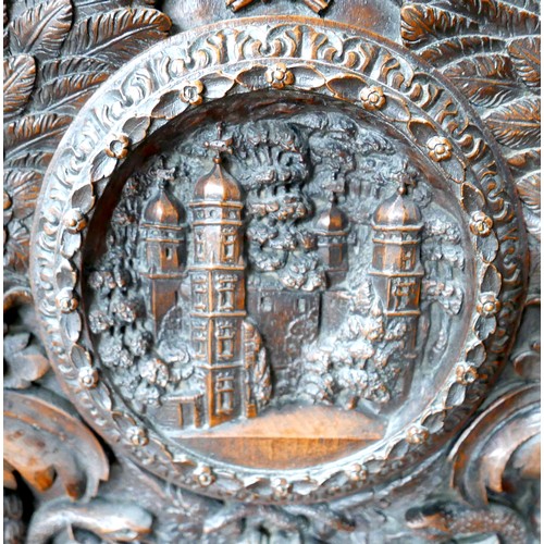 397 - The Burghley Chair: a Victorian heavily carved oak Armorial hall chair, dated 1866, profusely carved... 