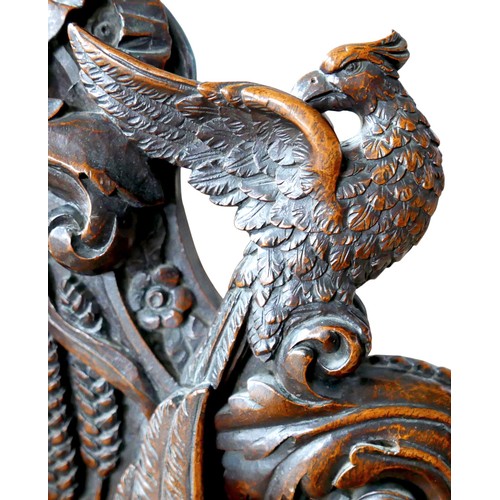 397 - The Burghley Chair: a Victorian heavily carved oak Armorial hall chair, dated 1866, profusely carved... 