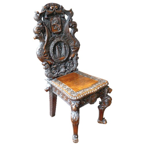 397 - The Burghley Chair: a Victorian heavily carved oak Armorial hall chair, dated 1866, profusely carved... 