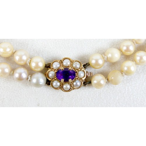47 - A twin strand pearl necklace with 9ct gold clasp set with faceted amethyst.