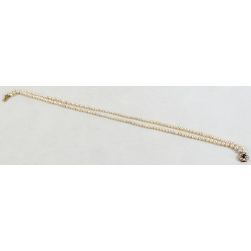 47 - A twin strand pearl necklace with 9ct gold clasp set with faceted amethyst.