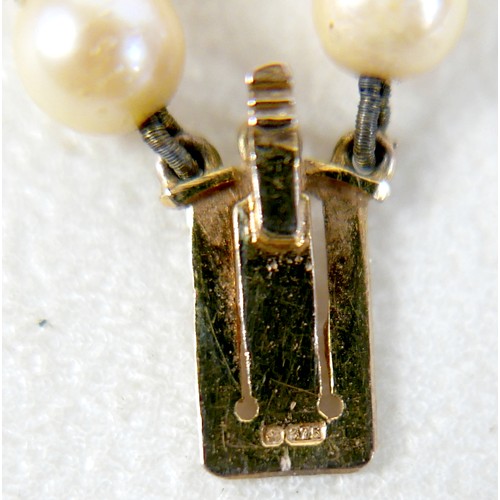 47 - A twin strand pearl necklace with 9ct gold clasp set with faceted amethyst.