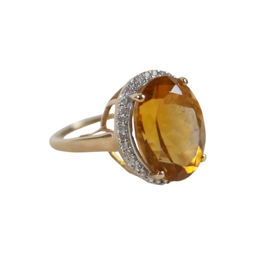 37 - A 10k gold ring set with large oval golden citrine and flowerhead border of small zircon, size S, 5.... 