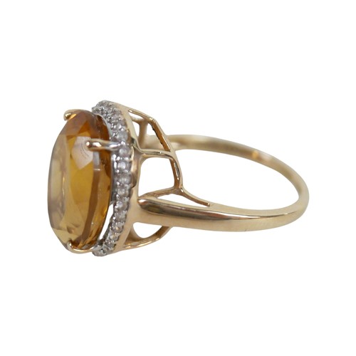 37 - A 10k gold ring set with large oval golden citrine and flowerhead border of small zircon, size S, 5.... 
