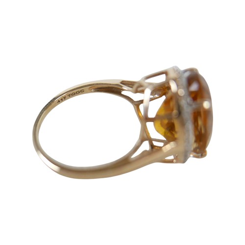 37 - A 10k gold ring set with large oval golden citrine and flowerhead border of small zircon, size S, 5.... 