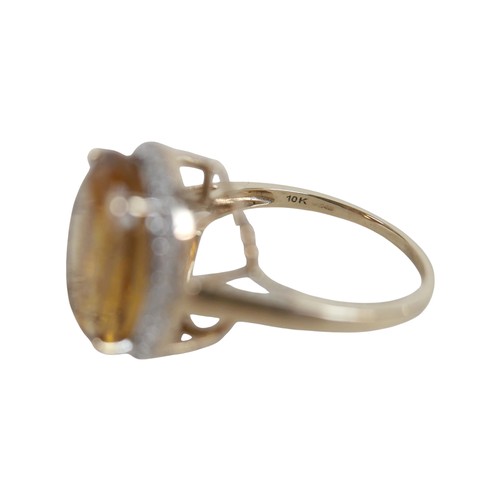 37 - A 10k gold ring set with large oval golden citrine and flowerhead border of small zircon, size S, 5.... 
