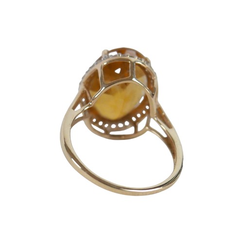 37 - A 10k gold ring set with large oval golden citrine and flowerhead border of small zircon, size S, 5.... 