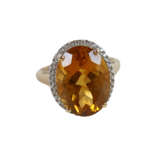 37 - A 10k gold ring set with large oval golden citrine and flowerhead border of small zircon, size S, 5.... 