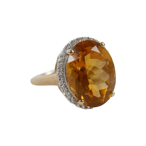 37 - A 10k gold ring set with large oval golden citrine and flowerhead border of small zircon, size S, 5.... 