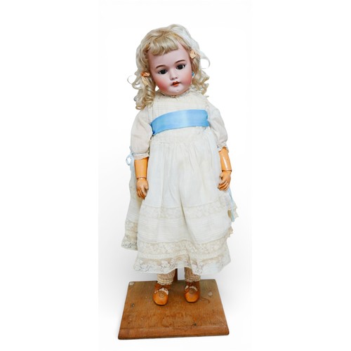 27 - A large Simon & Halbig doll, with glass eyes, painted features, an open mouth with an upper row of p... 