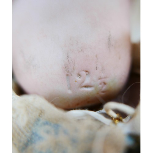 35 - A late 19th century/early 20th century continental bisque headed doll, with sleepy eyes, hand painte... 