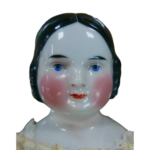 48 - A 19th century German porcelain shoulder-head pink tinted doll, with Covered wagon style painted hai... 