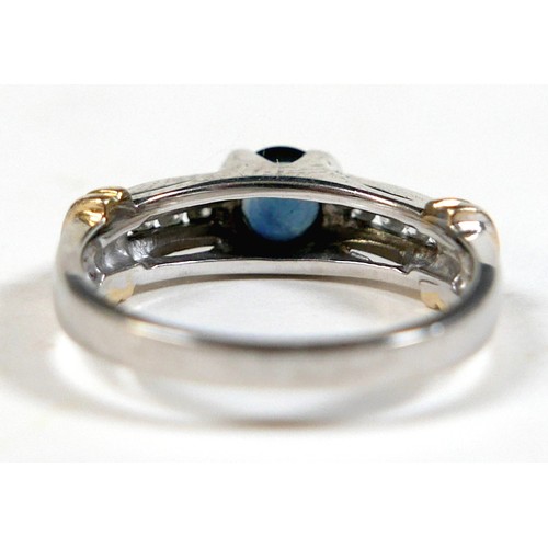 156 - An 18ct gold sapphire and diamond ring, the central round cut sapphire approximately 5mm diameter, w... 