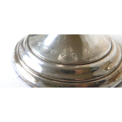 170 - A pair of Elizabeth II silver hurricane lamps with a rose column on a weighted circular footed base ... 