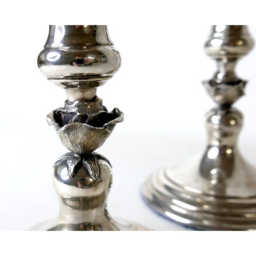 170 - A pair of Elizabeth II silver hurricane lamps with a rose column on a weighted circular footed base ... 