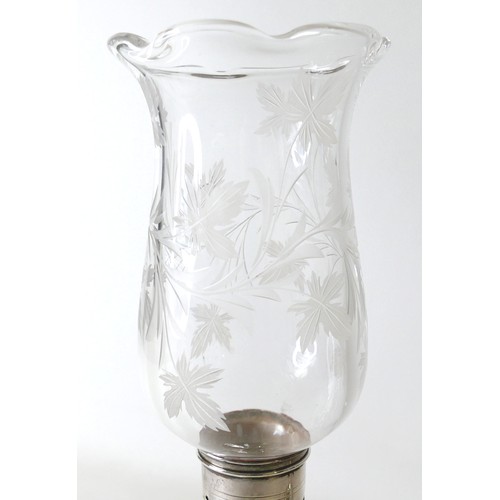 170 - A pair of Elizabeth II silver hurricane lamps with a rose column on a weighted circular footed base ... 