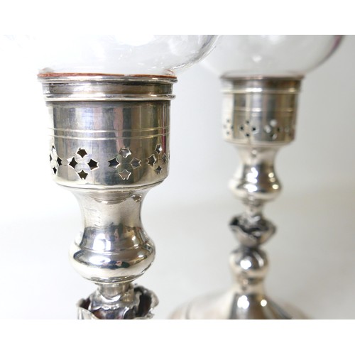 170 - A pair of Elizabeth II silver hurricane lamps with a rose column on a weighted circular footed base ... 