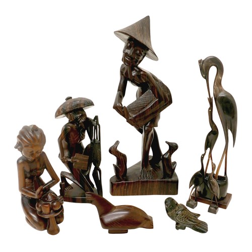 173 - A collection of four wooden carved figures, to include a woman kneeling, signed 'Rema Bali' to base,... 